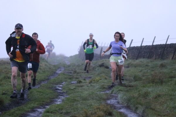 Runners approaching the camera, it is raining