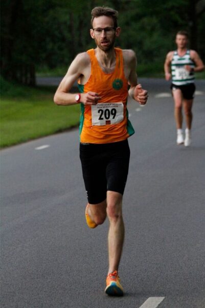 Seth Kirby running towards camera, another runner behind several metres distant