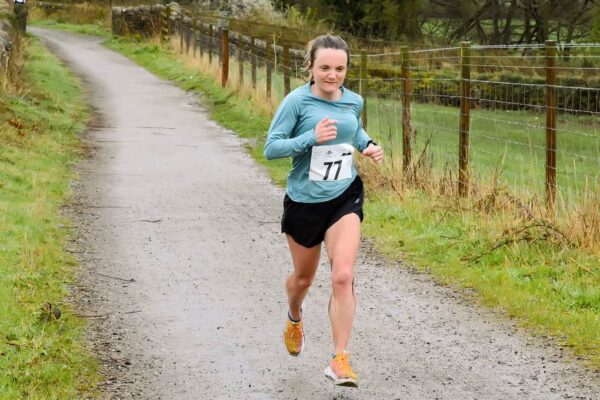 Sian Evans running towards the photographer on a well-made trail