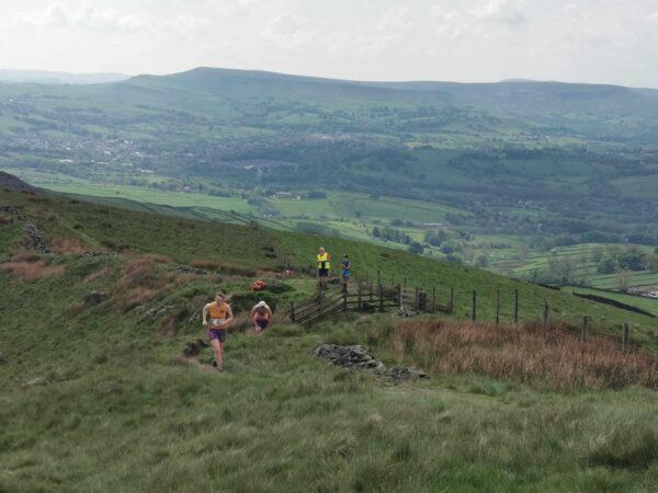 Sarah Thorne leads a group of runners near the top of a hill, with other hills in the distance