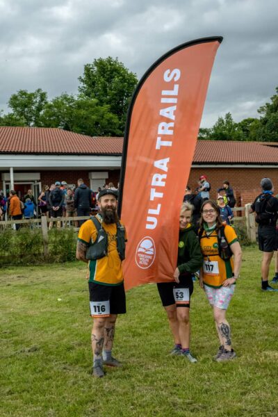 Laura, Jim and Melanie stood by an "Ultra Trails" banner.